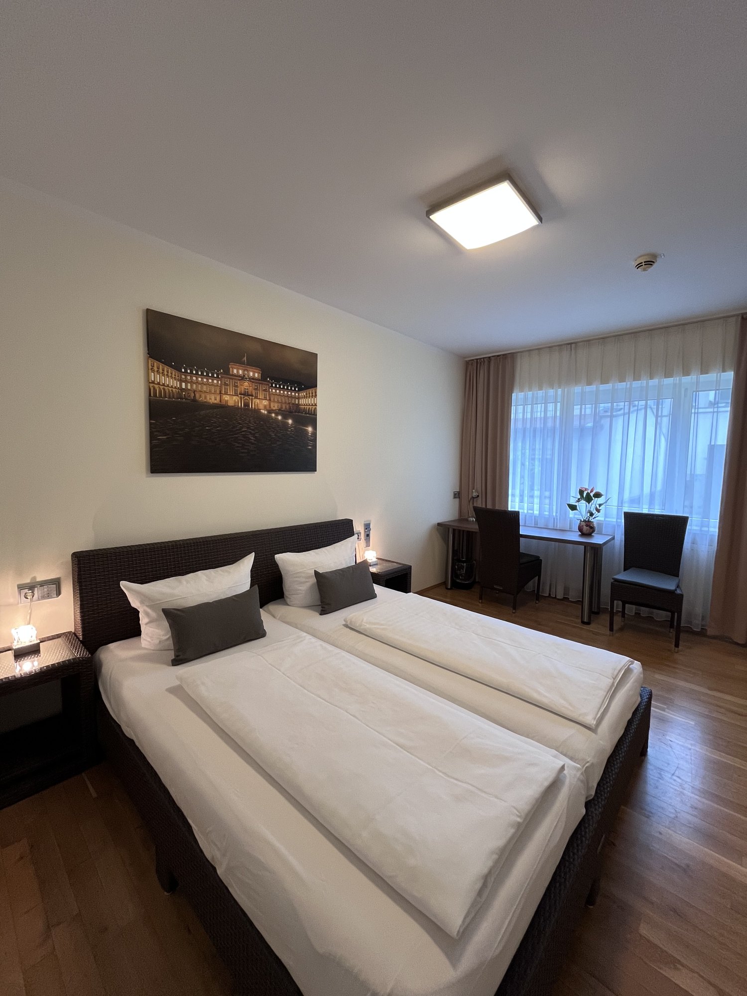Studio mit Doppelbett, Parkettboden und Wandbild des Mannheimer Schlosses