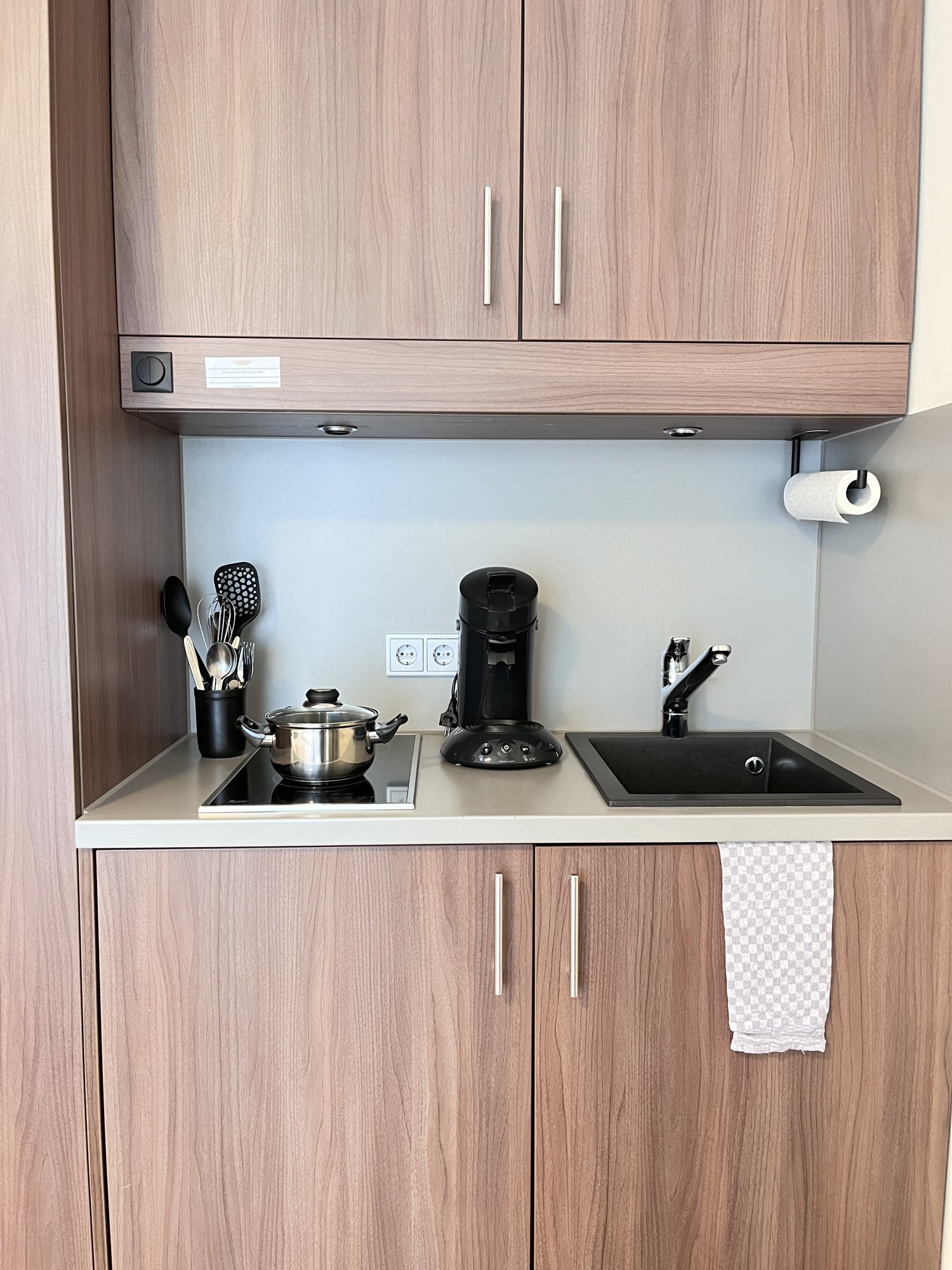 Kitchenette mit Induktionskochfeld, Kaffeemaschine und Spüle