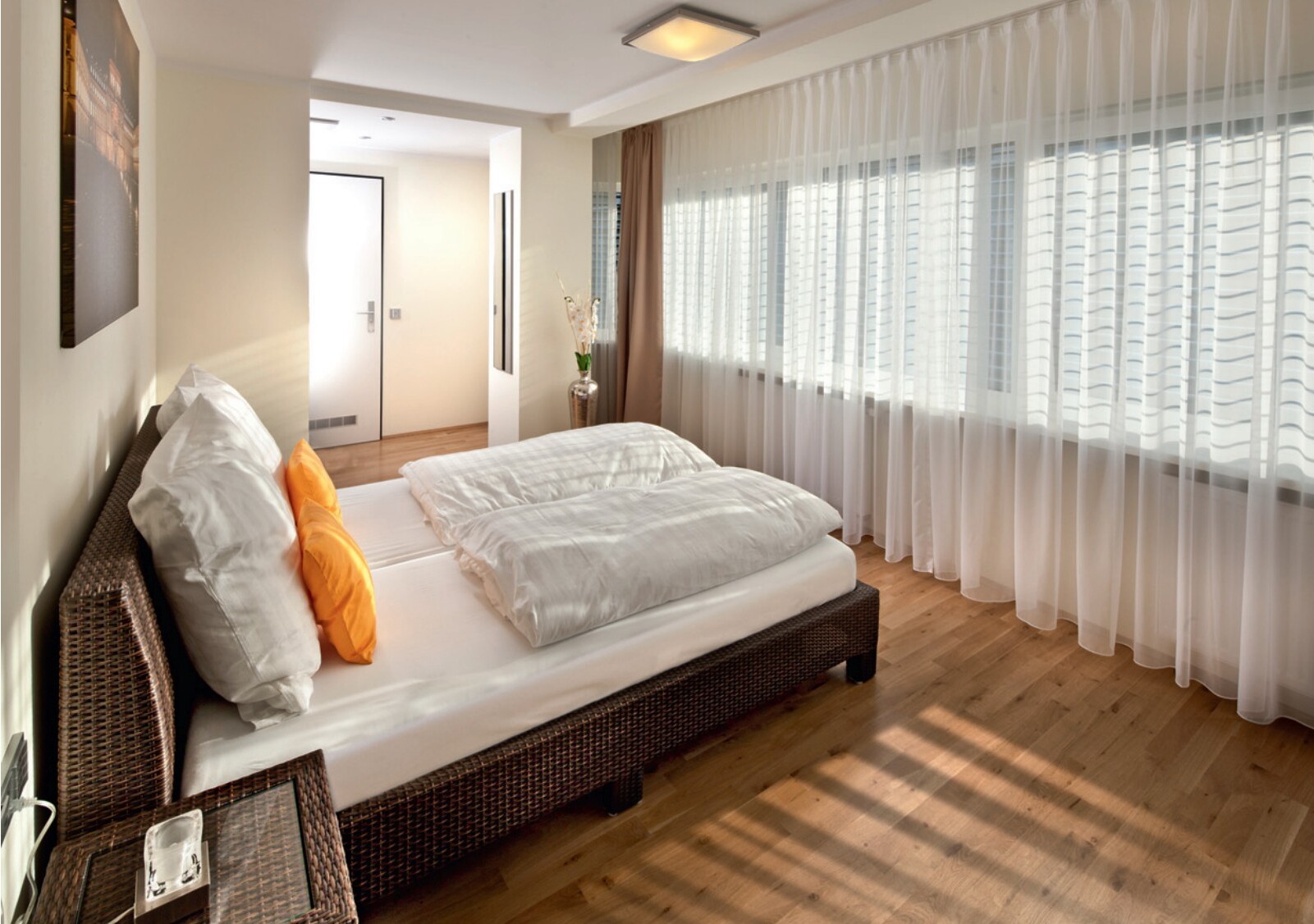 Helles Schlafzimmer mit Doppelbett und Vorhängen